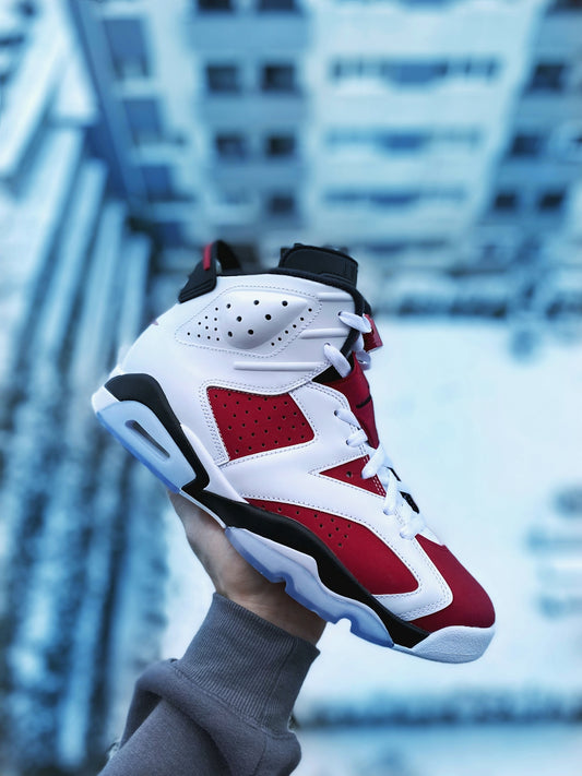 person wearing white red and black nike basketball shoe