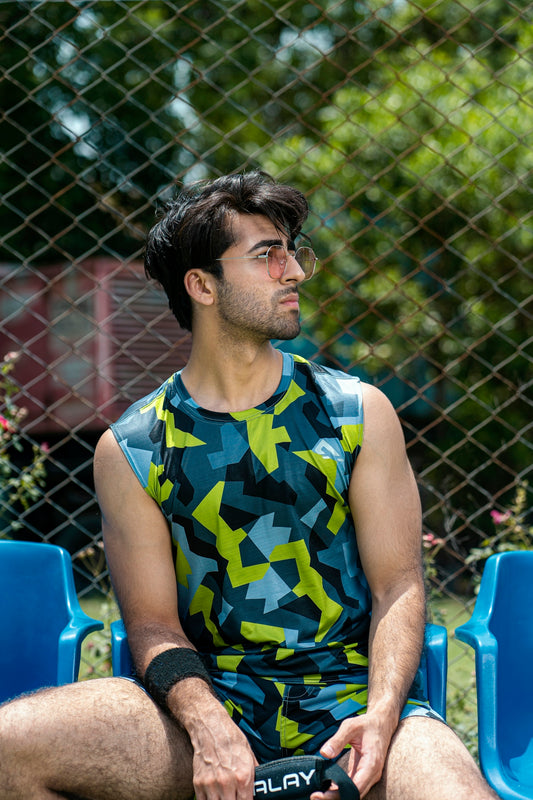 a man sitting on a blue chair in front of a chain link fence