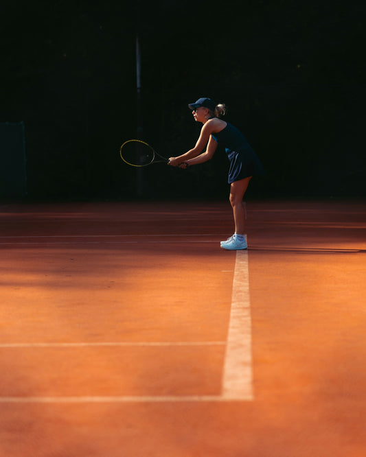 a woman holding a tennis racquet on a tennis court