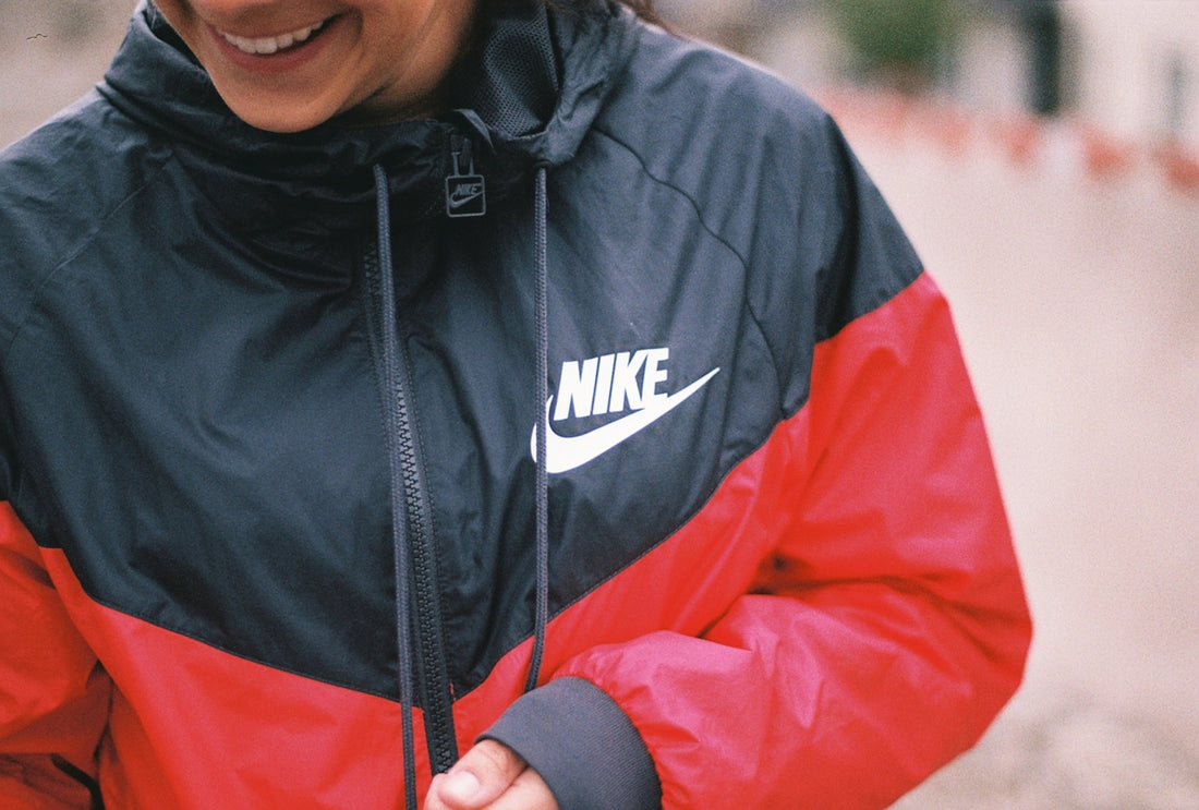 a woman in a black and red jacket smiles