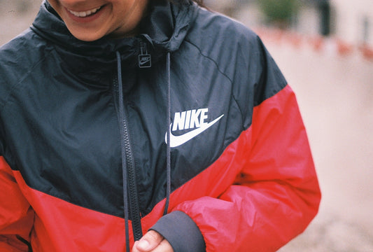 a woman in a black and red jacket smiles