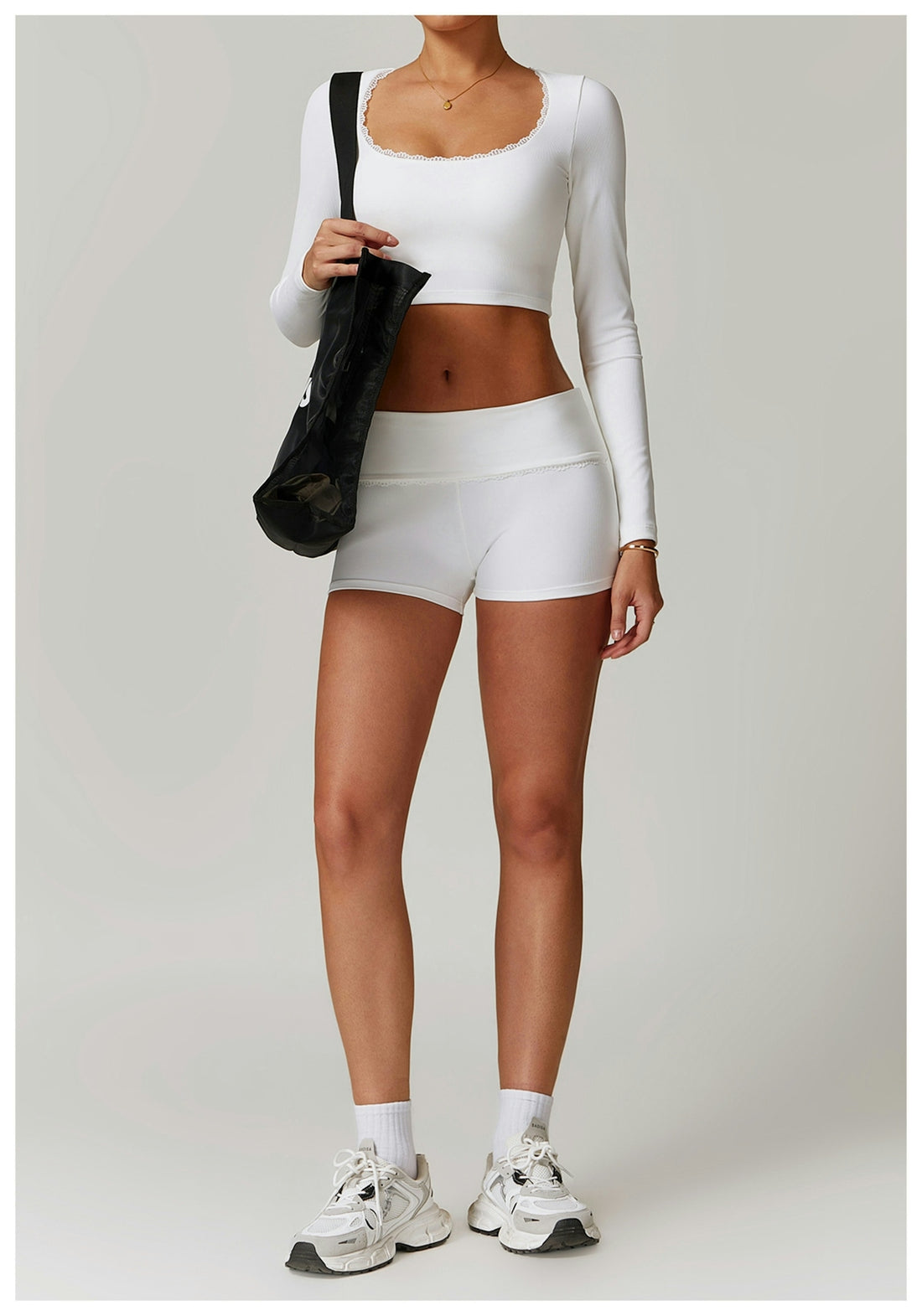 Woman in athletic wear with a bag and sneakers.