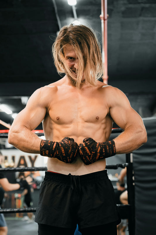 A shirtless man standing in a boxing ring