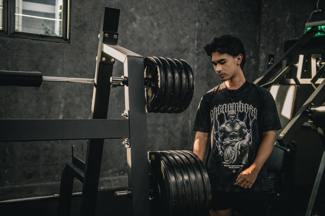 A man standing next to a barbell in a gym