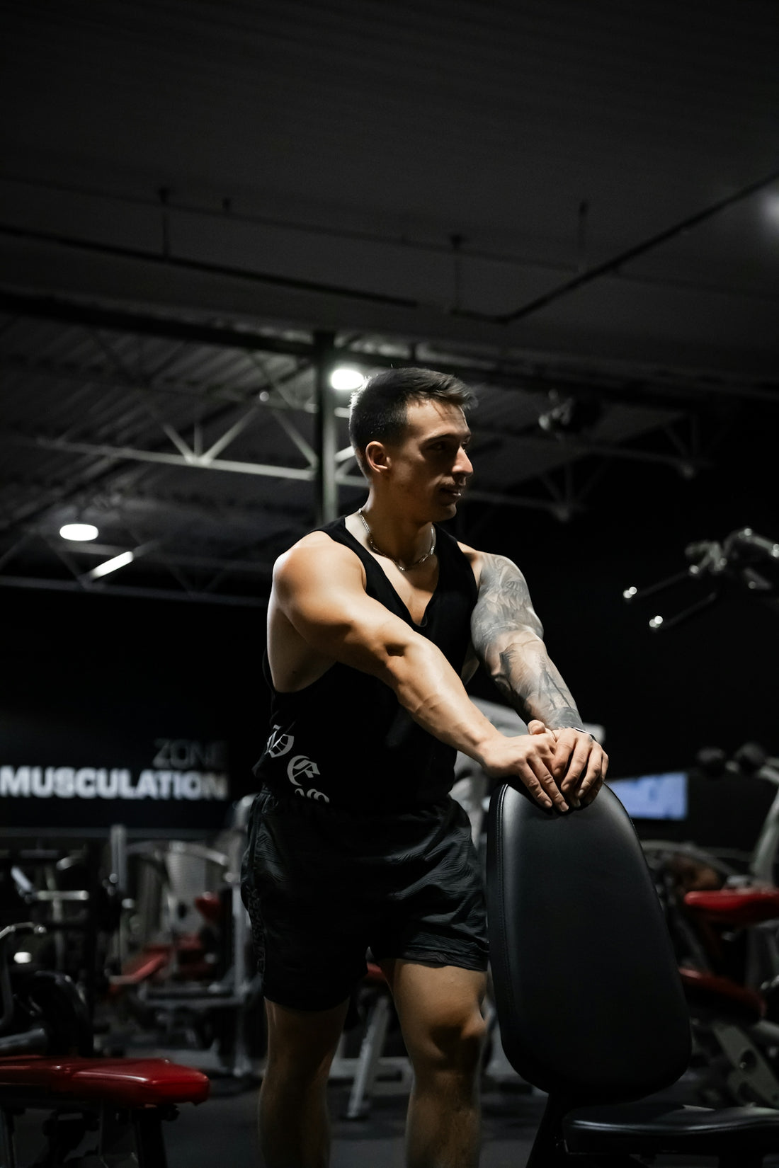 A man standing in a gym holding a weight machine