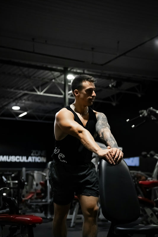 A man standing in a gym holding a weight machine