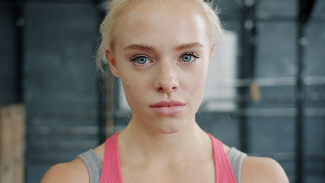 Blonde woman with blue eyes in gym attire