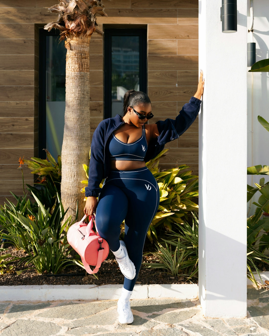 Woman in navy athletic wear with pink bag
