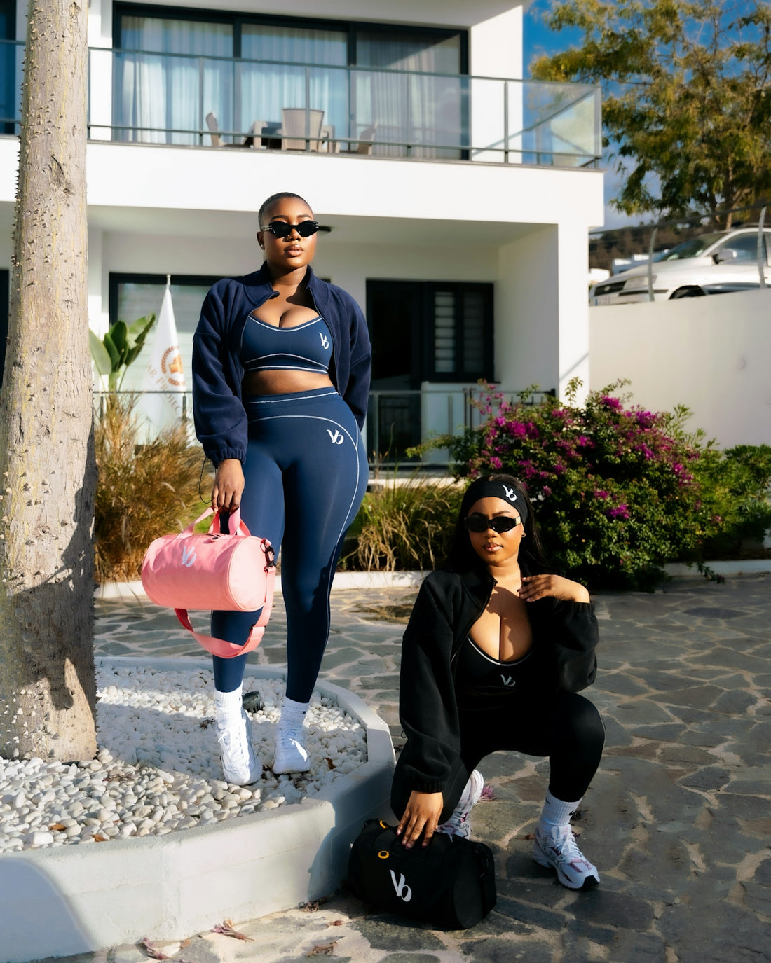 Two women in matching athletic wear posing outdoors