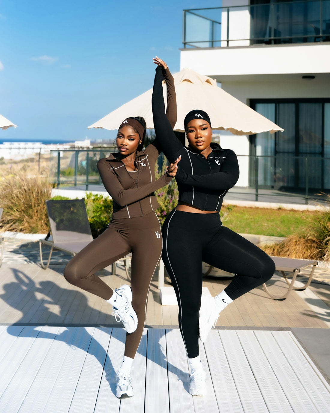 Two women in athletic wear striking a yoga pose