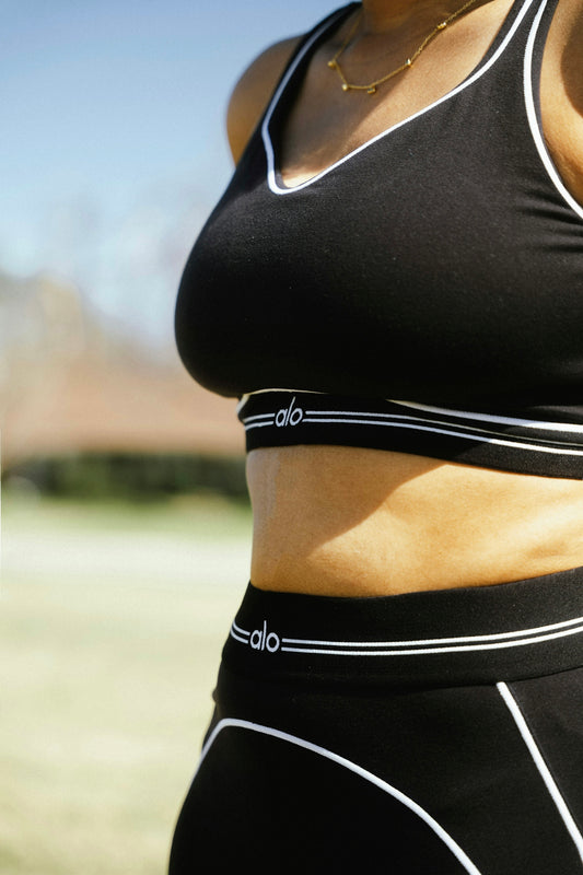 Woman in black athletic wear with white trim.