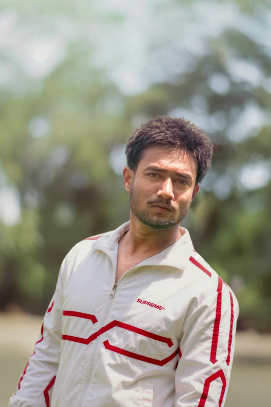 A man in a white jacket with red accents outdoors