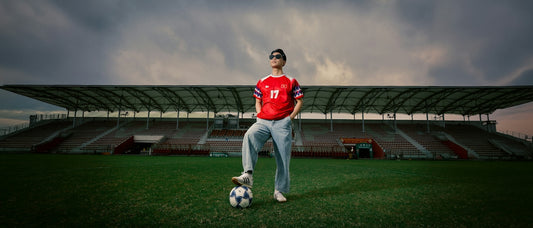 Soccer player with foot on ball in an empty stadium