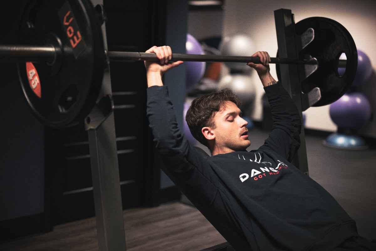 Person lifting a barbell in a gym setting
