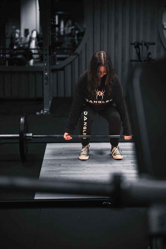 Person lifting a barbell in a gym setting