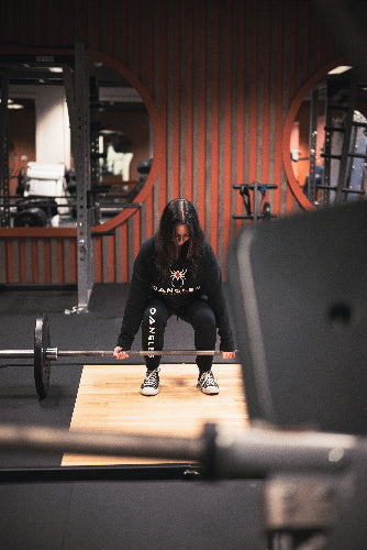 Person lifting a barbell in a gym setting